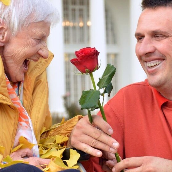 Ein Fahrer von MTK überreicht einer Seniorin eine Rose
